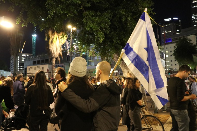 Guy Anitz, 30, right, and Tammy Chen, 30, left, joined the demonstration outside Israel's defense ministry in Tel Aviv tonight after the IDF announced it had mistakenly killed three Israeli hostages held in northern Gaza.