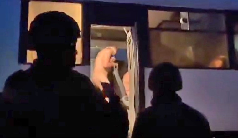 Israeli soldiers load naked Palestinian prisoners onto a bus.