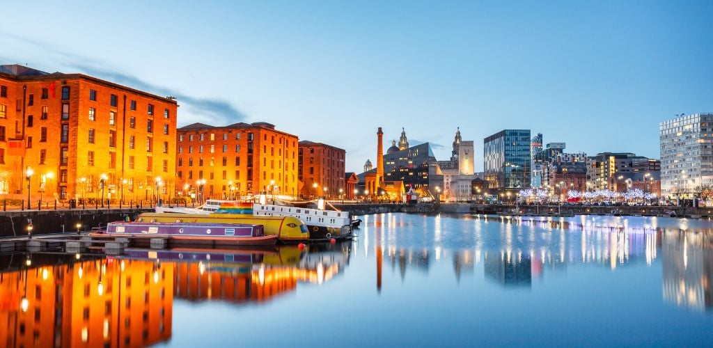 Albert Dock on the waterfront, as well as a boat dock on the side river. Buildings in the distance. 