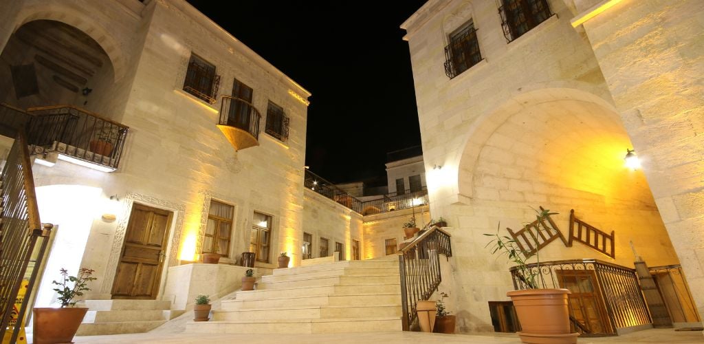 Outside view of the hotel, with stairs and plant pots in the corners. 