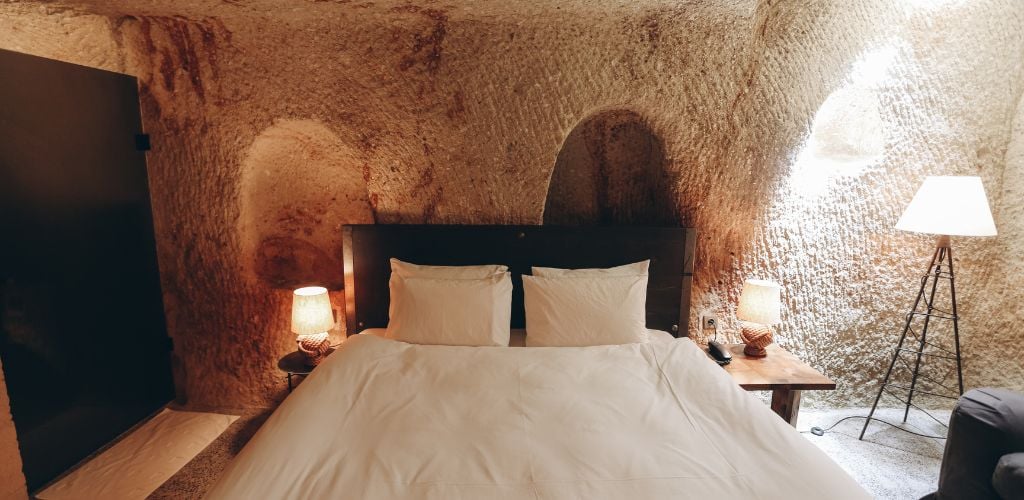 In a cave motel, there is one double bed and three lamps. 