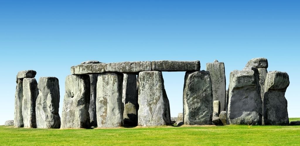 A historical monument Stonehenge. with green grass and blue sky. 