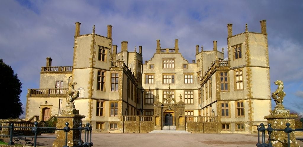 A historical castle with a statue on the side of the gate. 