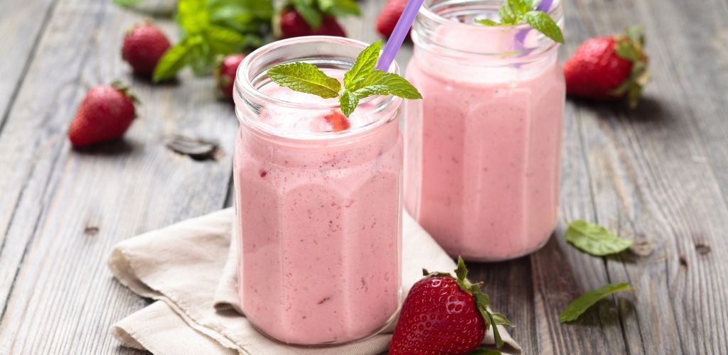 Fruit smoothie with mint leaves on a wooden rustic table. 