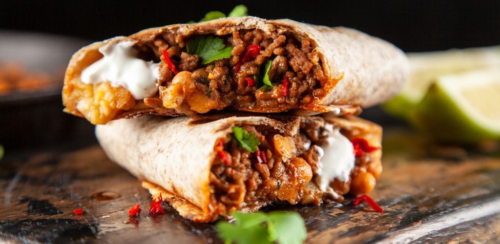 Mexican burrito with beef, beans, and sour cream. 