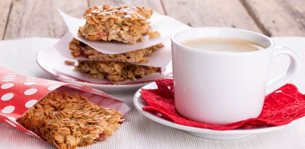 Flapjacks and a cup of coffee. Homemade healthy Oat bars with honey and currant. 