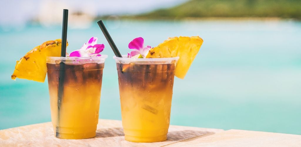 Mai tai drinks on beach bar travel vacation with view of ocean and mountain.