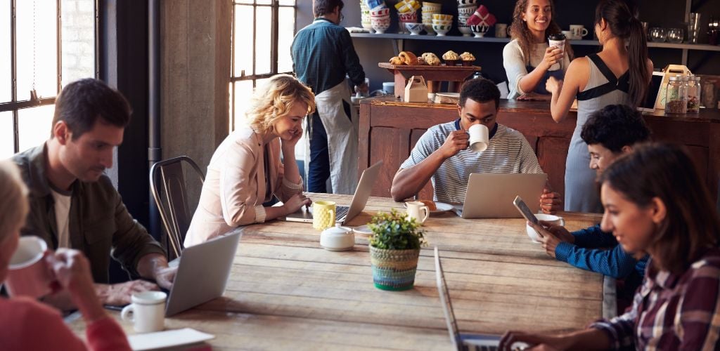 Interior of coffee shop with customers using digital devices. 