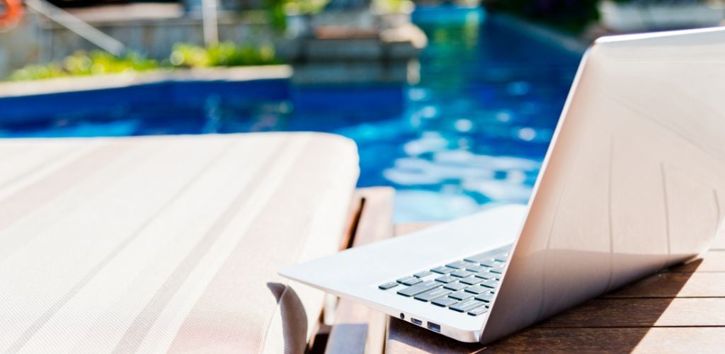 laptop beside a pool
