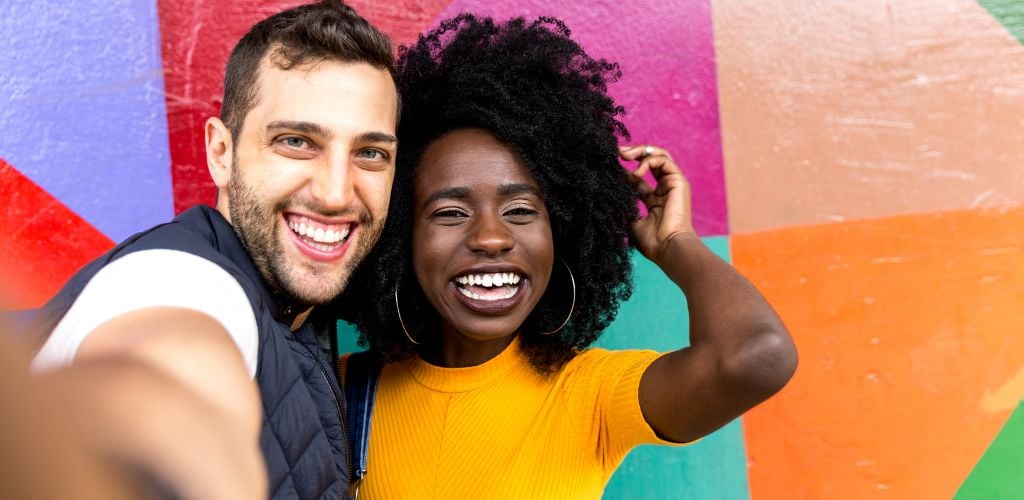 Couple taking selfie in the park with colorful background. 