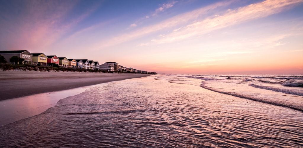 A summer scene on the beach with cottages in a line. 