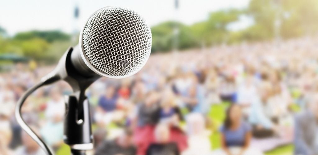 Outdoor music festival or concert: microphone with defocused audience