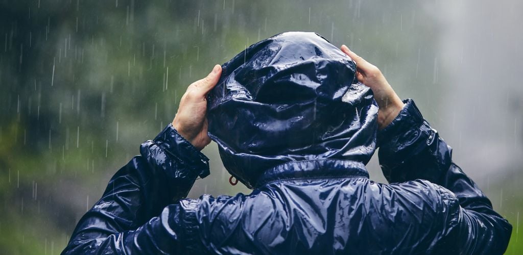 Traveler in heavy rain portable rain poncho.