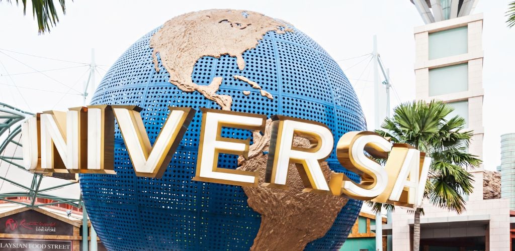 An Iconic globe of Universal Studio, tree, and tower structure in the background. 