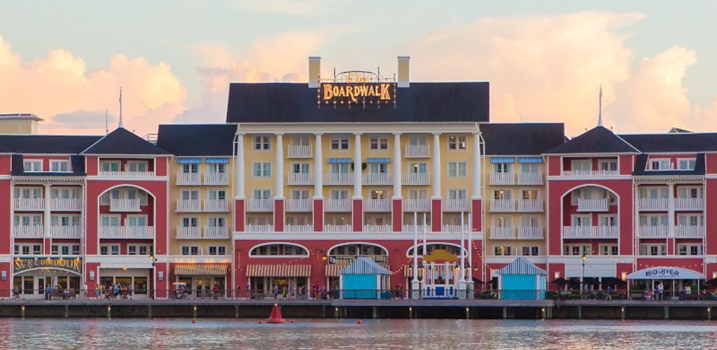 A yellow and red building structure with Boardwalk signage in front of the lake. 