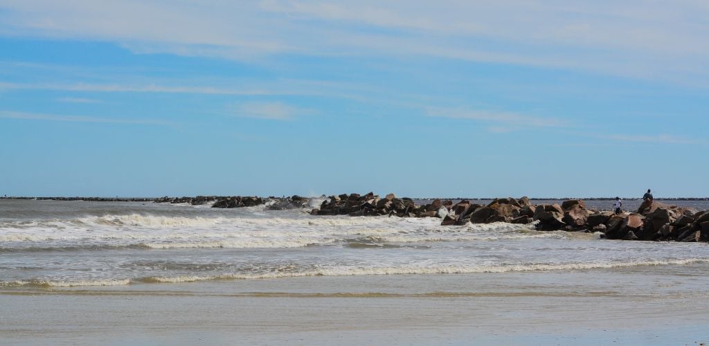 The sea water was divided by a wavy beach and a large number of large stones. 