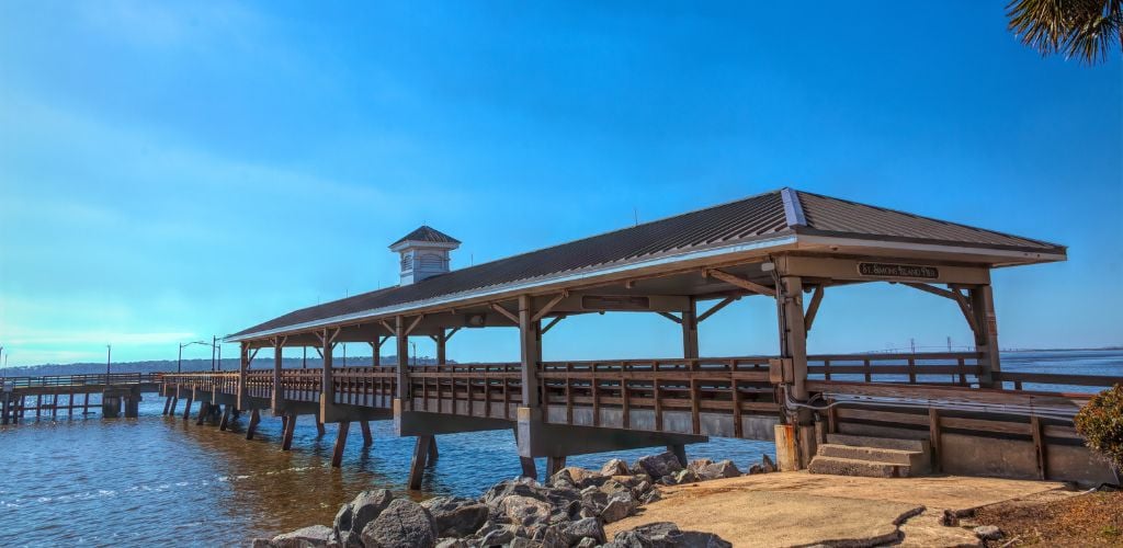 An old fishing pier on St. Simons Island beyond rock seawell. 