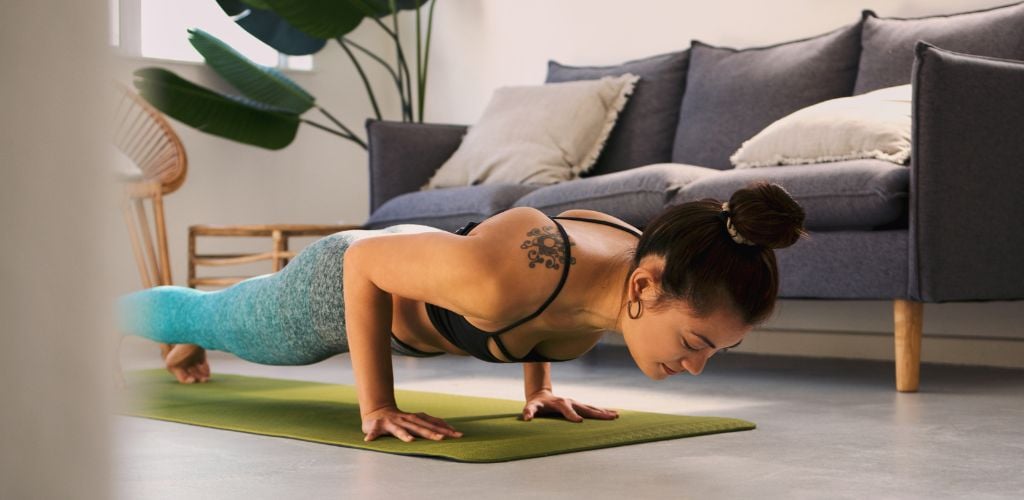 Shot of a young woman exercising at home. 