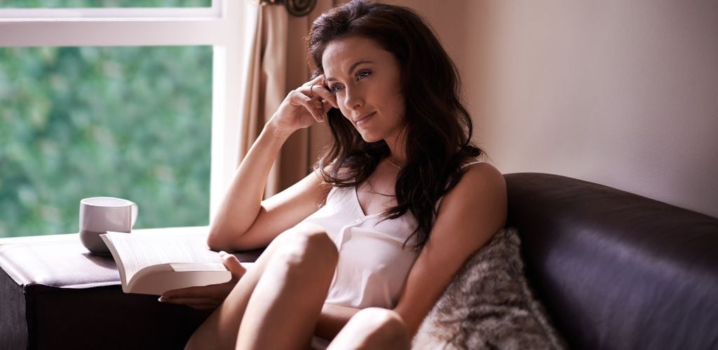 Shot of a beautiful woman relaxing with a book at home. A best time reflecting your self when you are alone. 