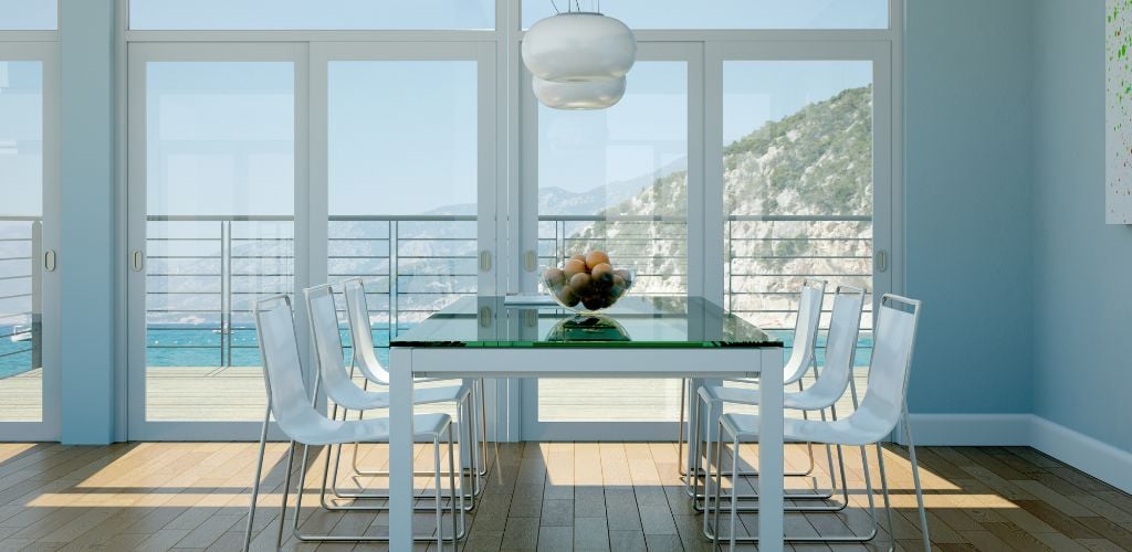 A dining room and a beach and mountain on the out side. 