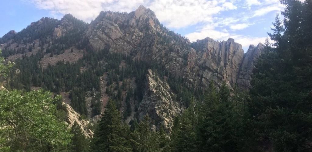 A large mountain with a green tree surrounding it. 