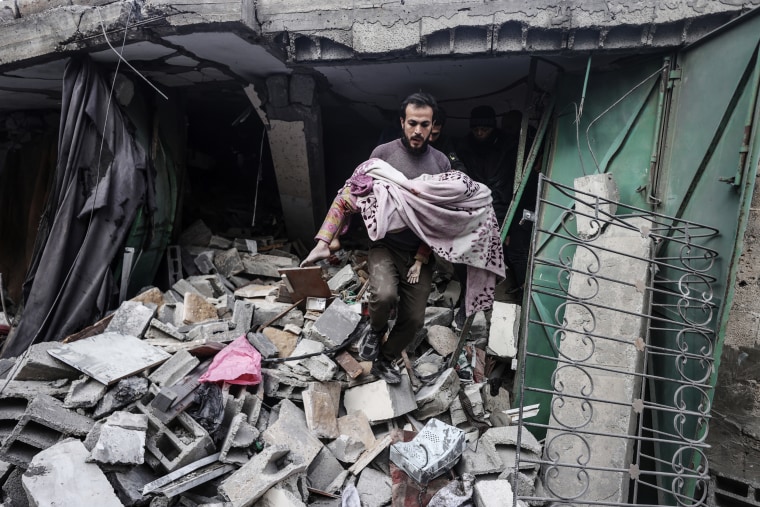A child's body is removed from the rubble of the al-Wawawi family's house in Gaza City on Dec. 30, 2023.