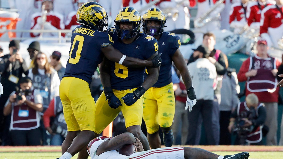 Mike Sainristil and Derrick Moore celebrate a sack