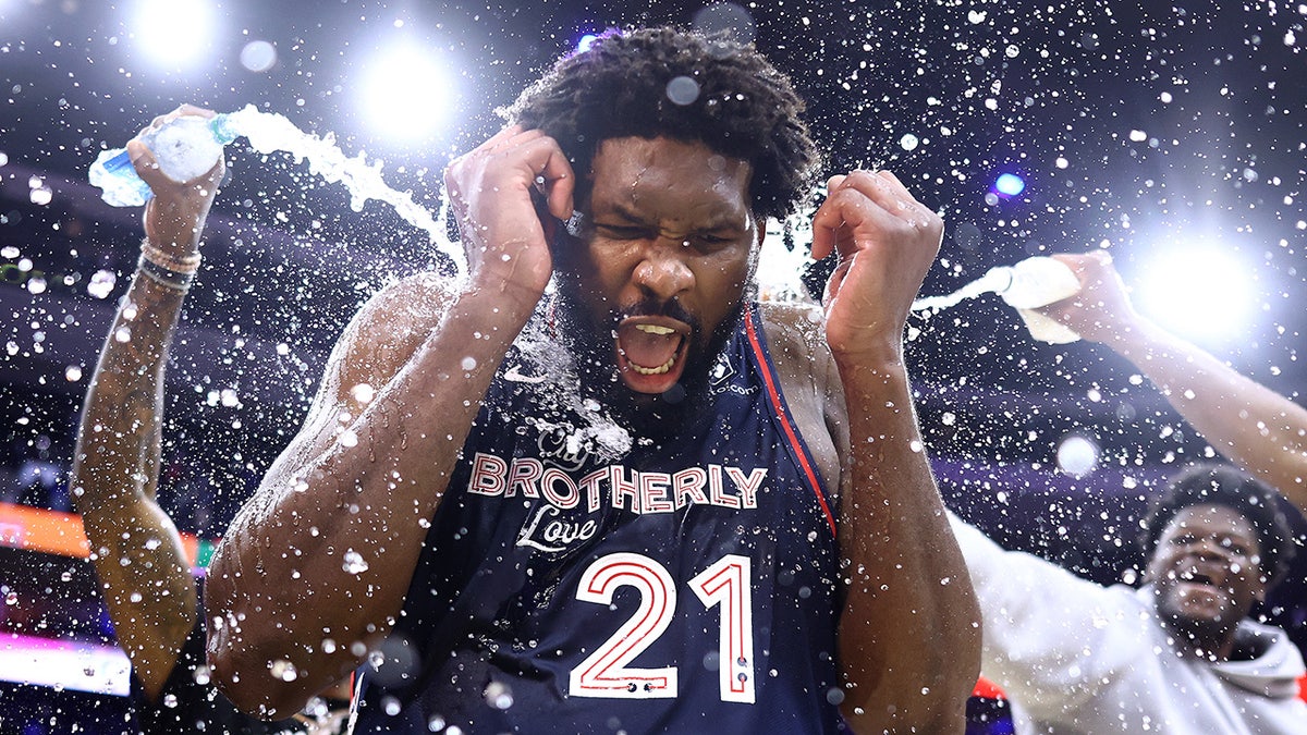 Joel Embiid showered by water bottles