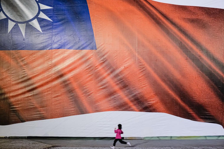 A child runs across the flag of Taiwan banner during the announcement of official results in Taipei, Taiwan on Jan. 13, 2024. 