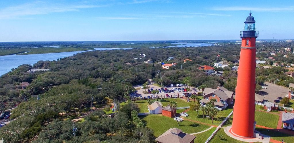 An aerial view of Ponce de Leon Inlet Lighthouse & Museum, trees, lakes, and houses. 