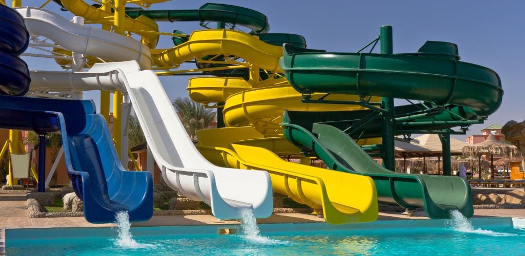 Colorful waterpark tubes and pool in a tropical climate. 
