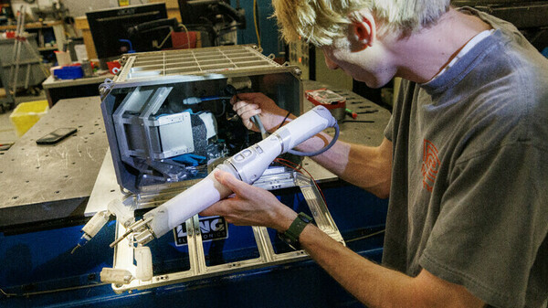 Sean Crimmins, a senior in engineering at the University of Nebraska, loads the robotic arm into its case on Aug. 11 before a shake test.