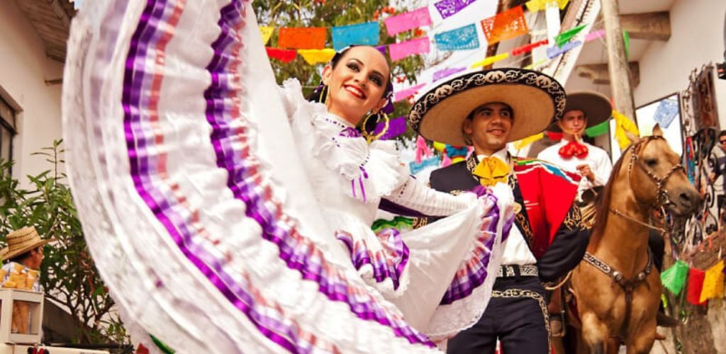 A man and a woman participate in the Folkloric Street Dance Festival, and a man rides a horse. 