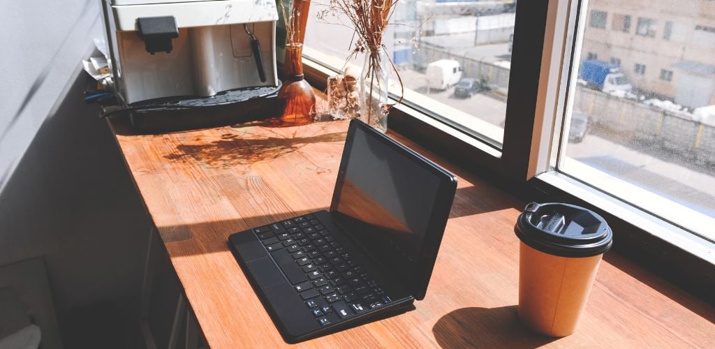 Work Area with Laptop and Coffee near the Window