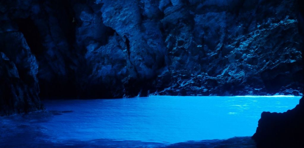 There is blue water in the cave. 