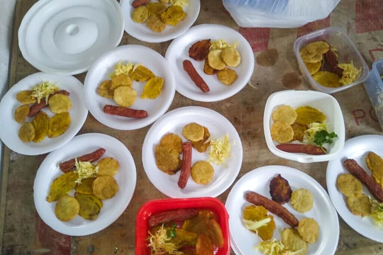 Styrofoam plates of plantains and hotdogs