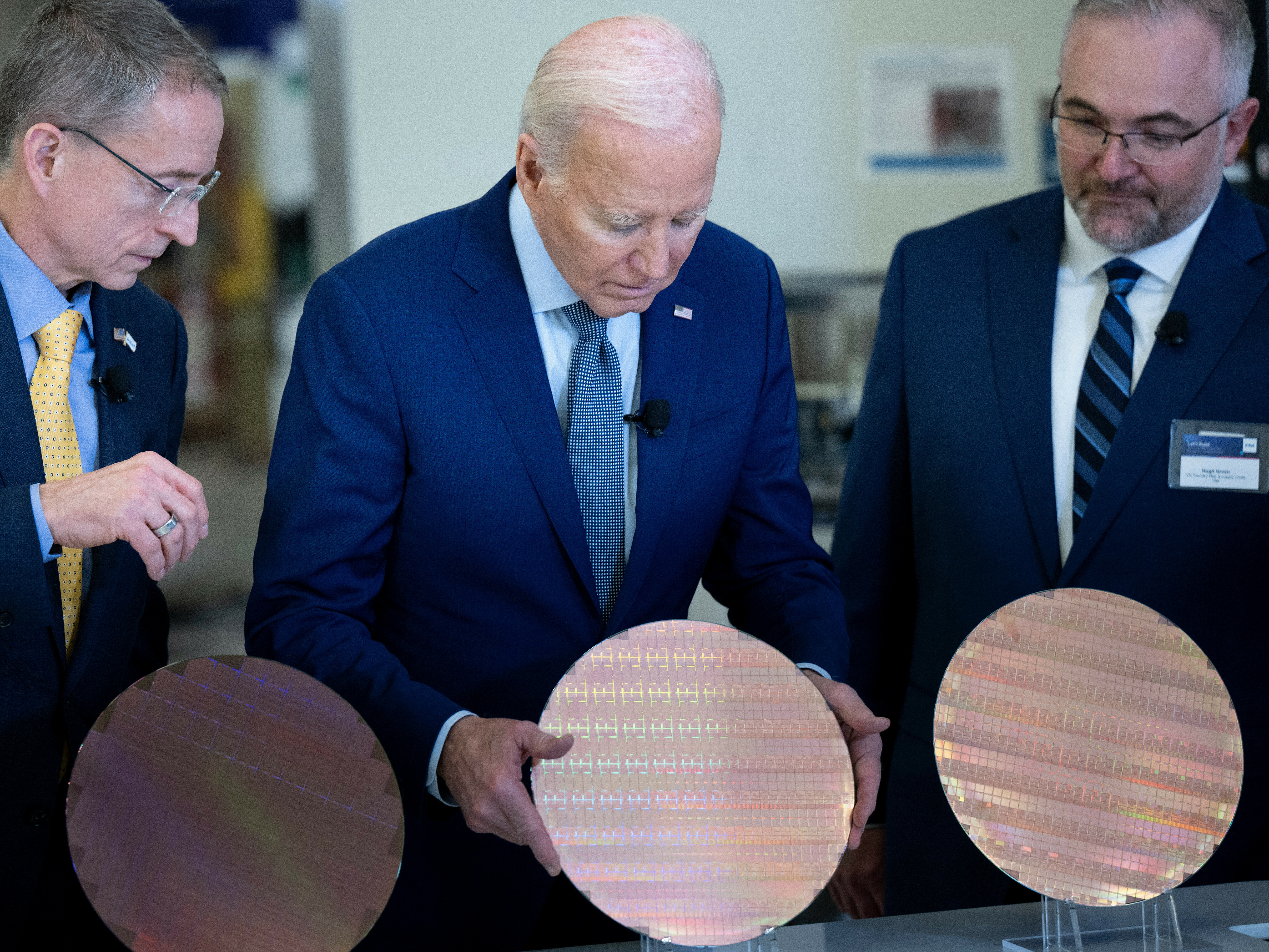 Intel CEO Pat Gelsinger (L) and Intel Factory Manager Hugh Green (R) watch as US President Joe Biden (C) looks at a semiconductor wafer during a tour at Intel Ocotillo Campus in Chandler, Arizona, this week. The White House unveiled almost $20 billion in new grants and loans Wednesday to support Intel