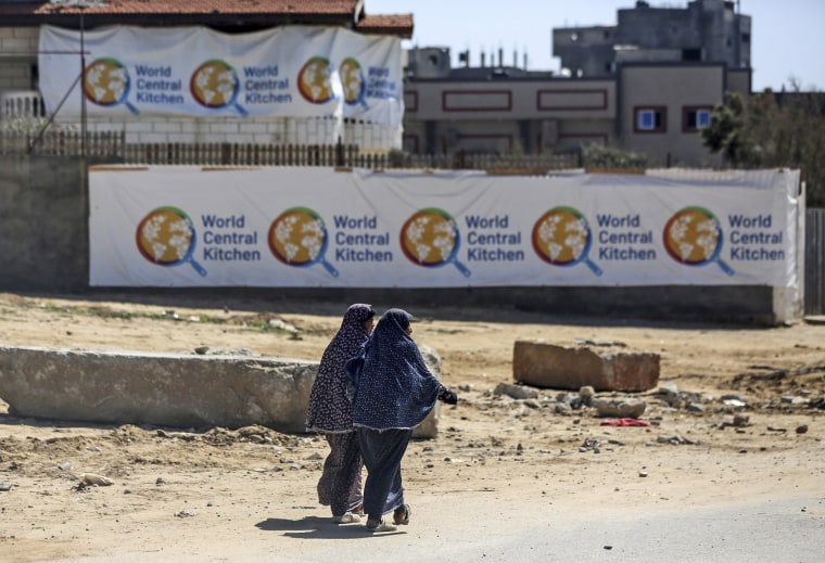 Palestinians walking in front of the closed headquarters of the World Central Kitchen on April 3, 2024, west of Nuseirat, central Gaza.