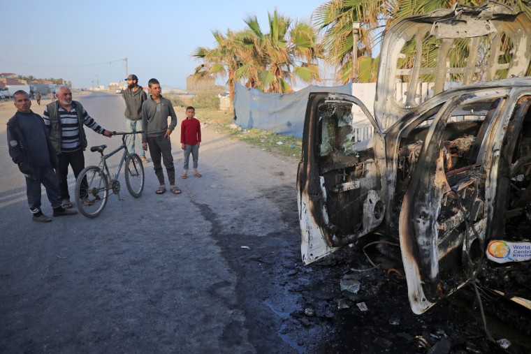 Palestinians look a vehicle in Deir Al-Balah, Gaza, on April 2, 2024, the day after it was destroyed by an Israeli airstrike that killed World Central Kitchen workers. 