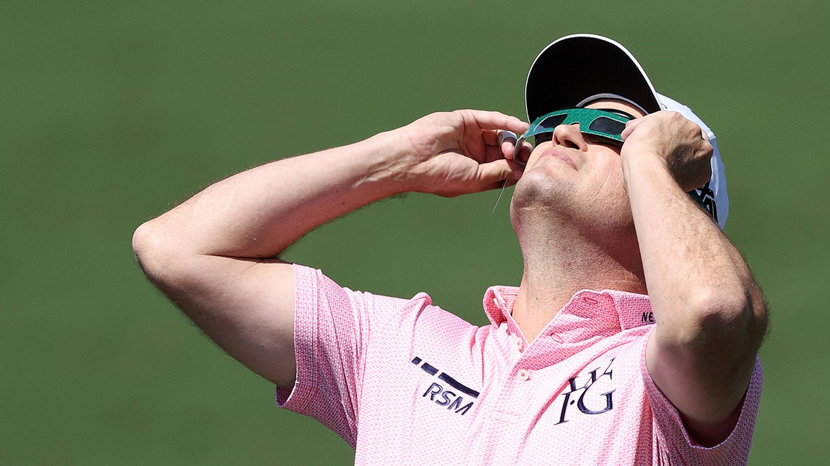 Zach Johnson looks up at solar eclipse