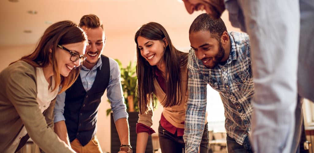 group of people discussing plans around a meeting table 