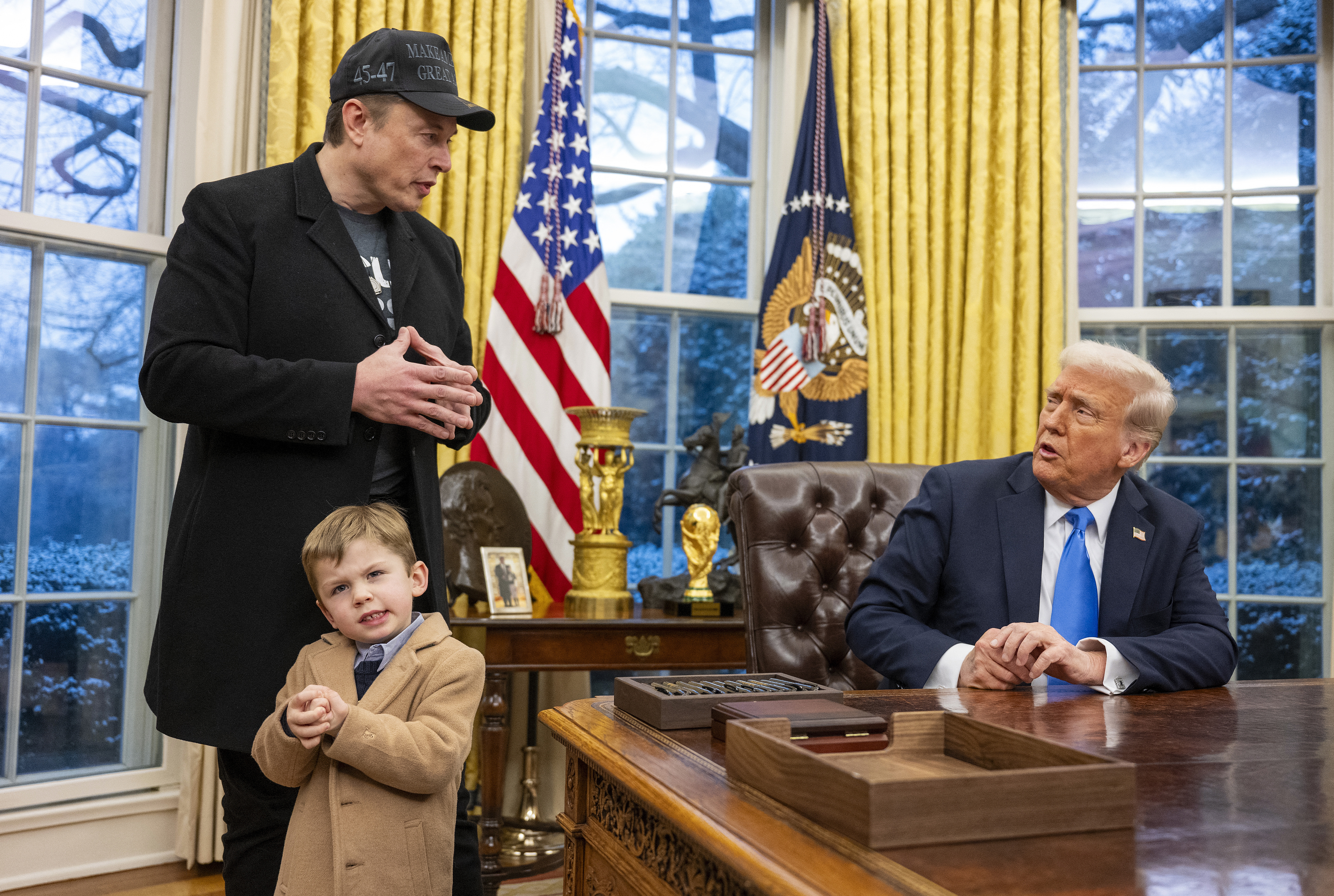Tesla and SpaceX CEO Elon Musk with his son X Æ A-Xii and President Trump in the Oval Office on Feb. 11. Musk has been tapped by President Trump to lead federal cost-cutting efforts.