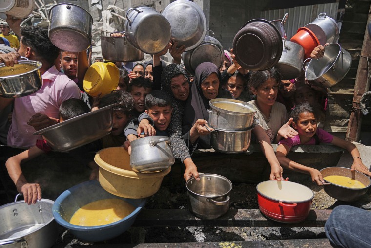 Palestinians struggle to get donated food at a community kitchen