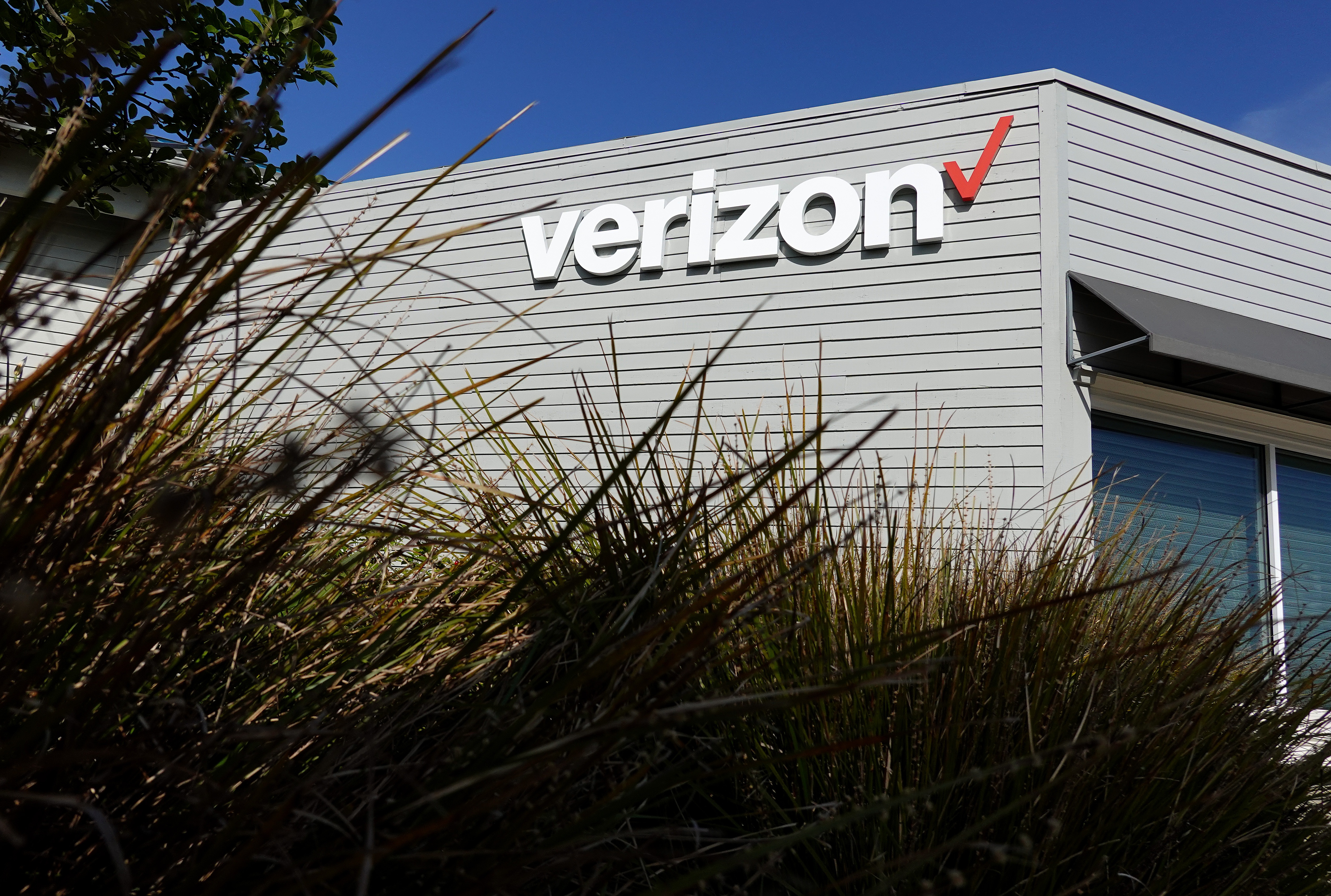 The Verizon logo is displayed on the exterior of a Verizon store. The FCC approved its $20 billion deal to buy Frontier Communications, a day after Verizon told the U.S. regulator that it would end many of its diversity-related policies.