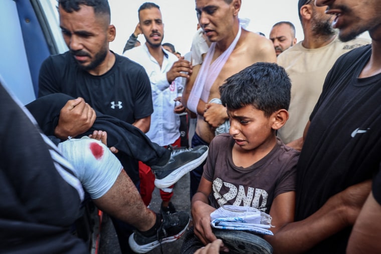 Palestinian rescuers evacuate injured people in an ambulance