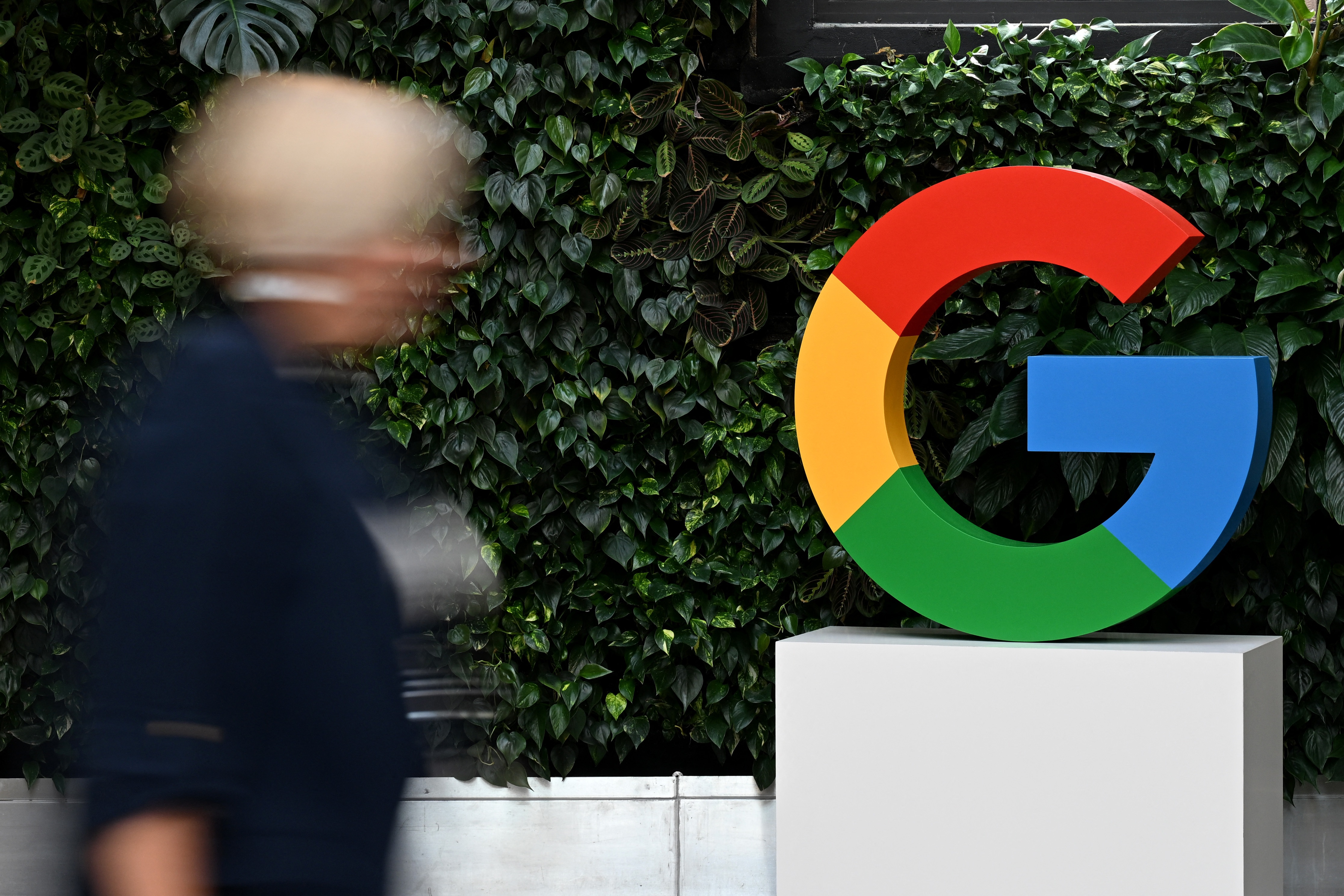 A woman walks past a Google logo at the Google Campus in Warsaw on Feb.13, 2025.