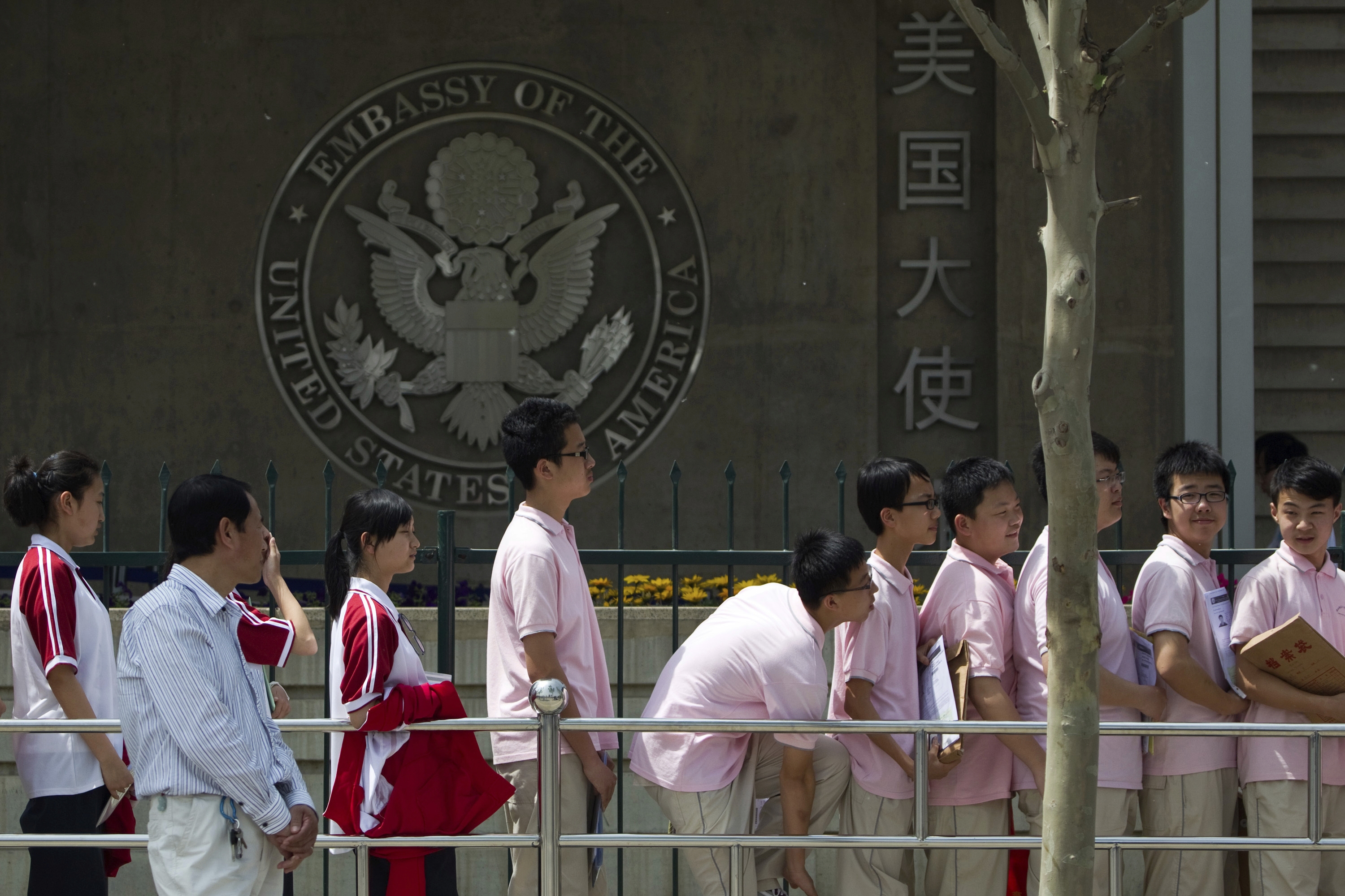 Chinese students wait outside the U.S. Embassy for their visa application interviews, in Beijing on May 2, 2012.