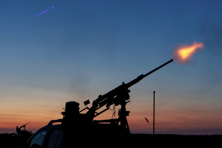 Ukrainian serviceman from mobile air defence unit fires a machine gun towards a Russian drone in Kharkiv region