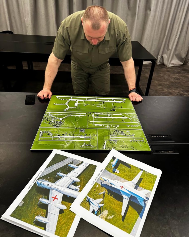 head of the Security Service Vasyl Malyuk studies a photo of a map of Russia's strategic aviation location