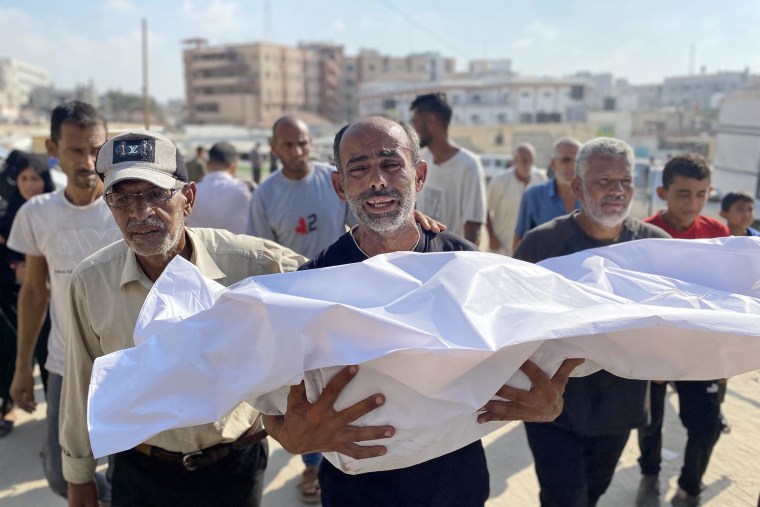 A mourner carries the body of a victim killed by Israeli bombardment on the Mawasi area of Khan Younis, during a funeral outside Nasser Medical Complex in Khan Younis on July 28, 2025.